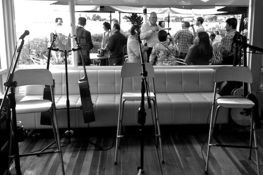 Stools and mics set up in front of a crowd at Sirens